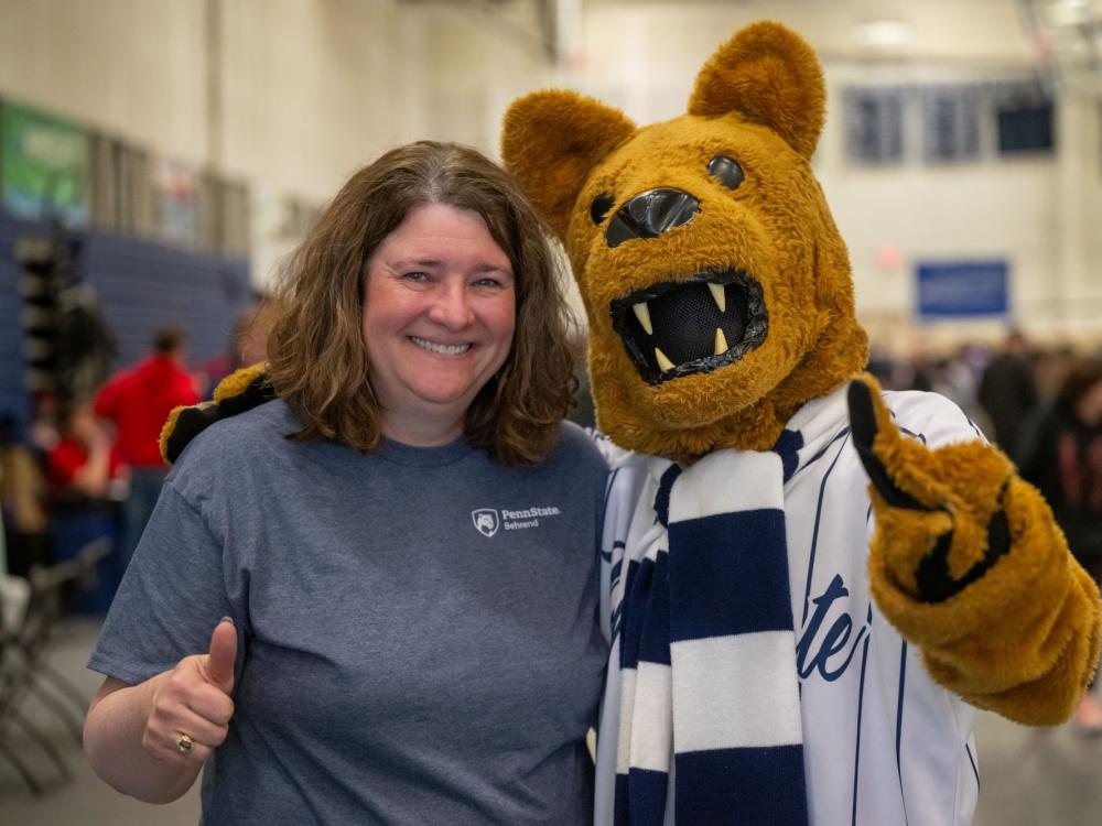 Melanie Ford, director of Youth Education Outreach at Penn State Behrend, poses with the Nittany Lion, giving a thumbs-up sign.