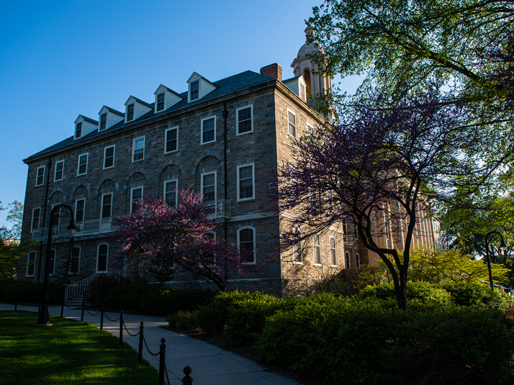 View of Old Main from the side and rear, with trees blooming in the spring