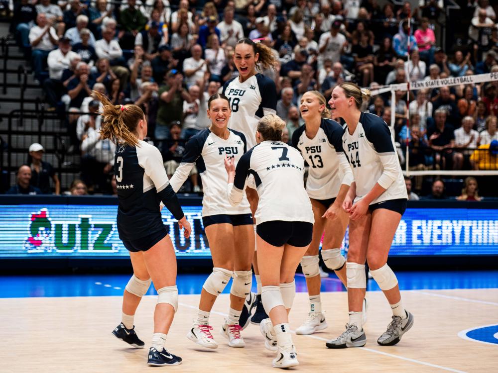 A group of women's volleyball players celebrate during a match