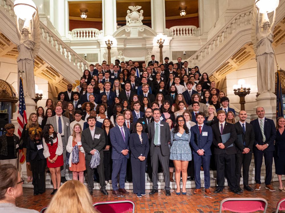 Large group of Penn State students and staff posed on the Pennsylvania Capitol staircase for a group photo.