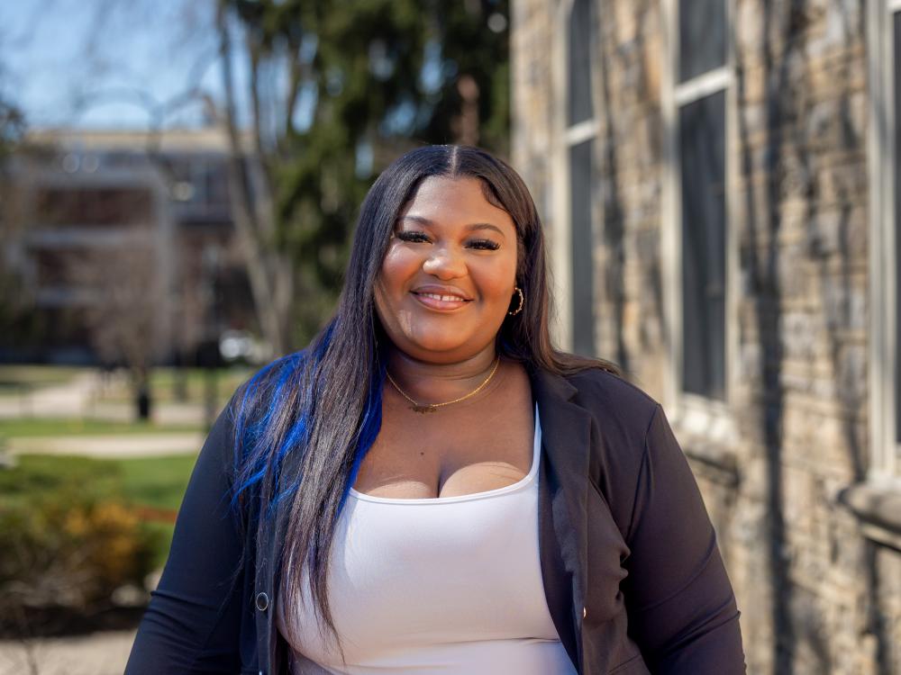 Shaquana Simpson stands outside Old Main Building on a sunny day.