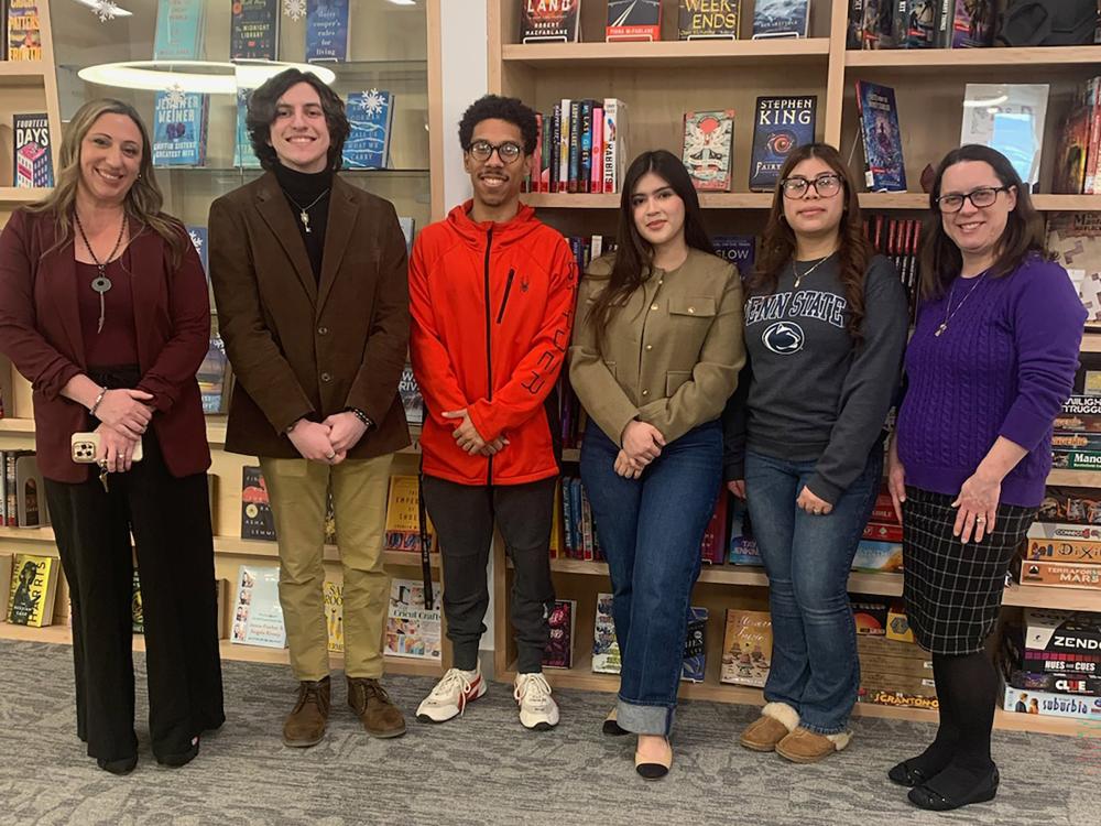 Student artists pose for a photo in the campus library