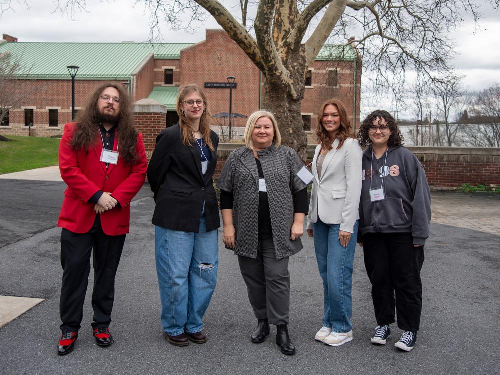 Five people stand outside