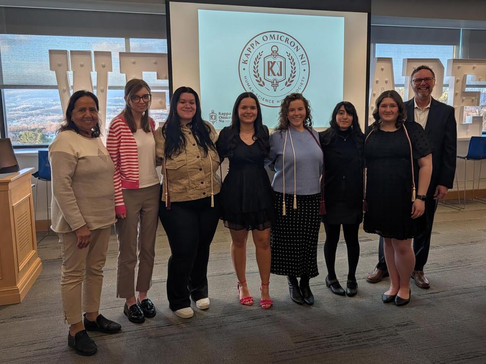 The group of new honor society inductees pose for a group photo in the Sherbine Lounge