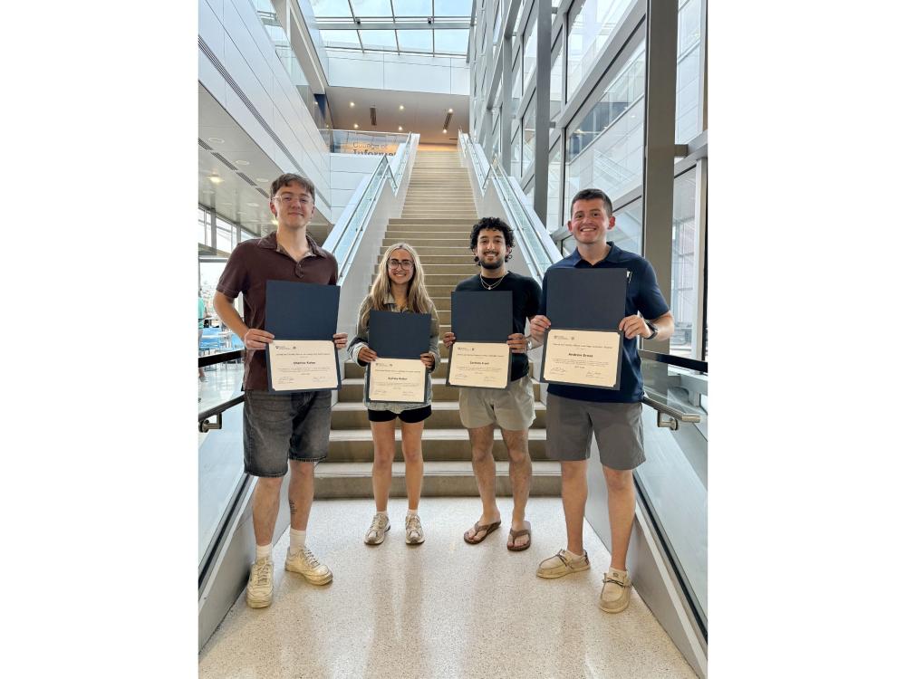 four college students display award certificates 
