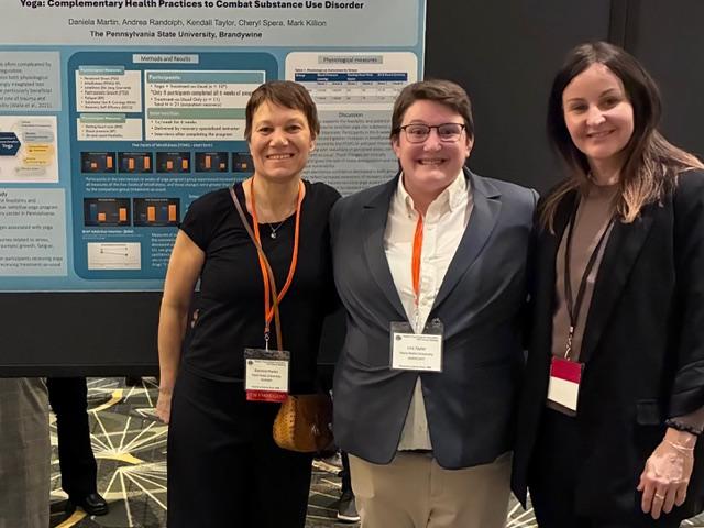 Daniela Martin, Kendall Taylor and Andrea Randolph standing in front of poster presenting findings