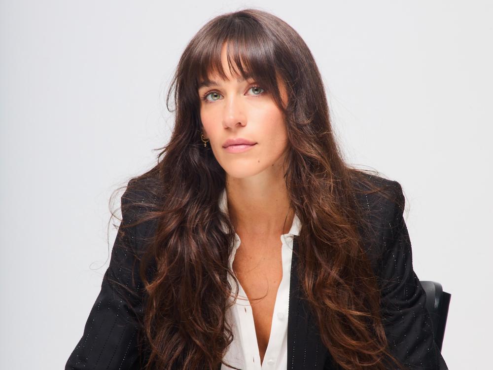 Woman with dark hair, a dark blazer and white shirt