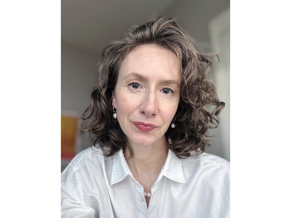 Kate Merkel-Hess wearing a white blouse. 