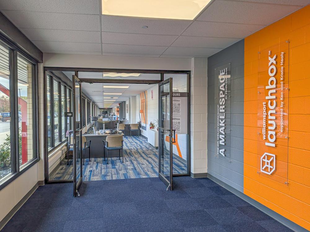A glass office doorway with an orange entrance wall sign