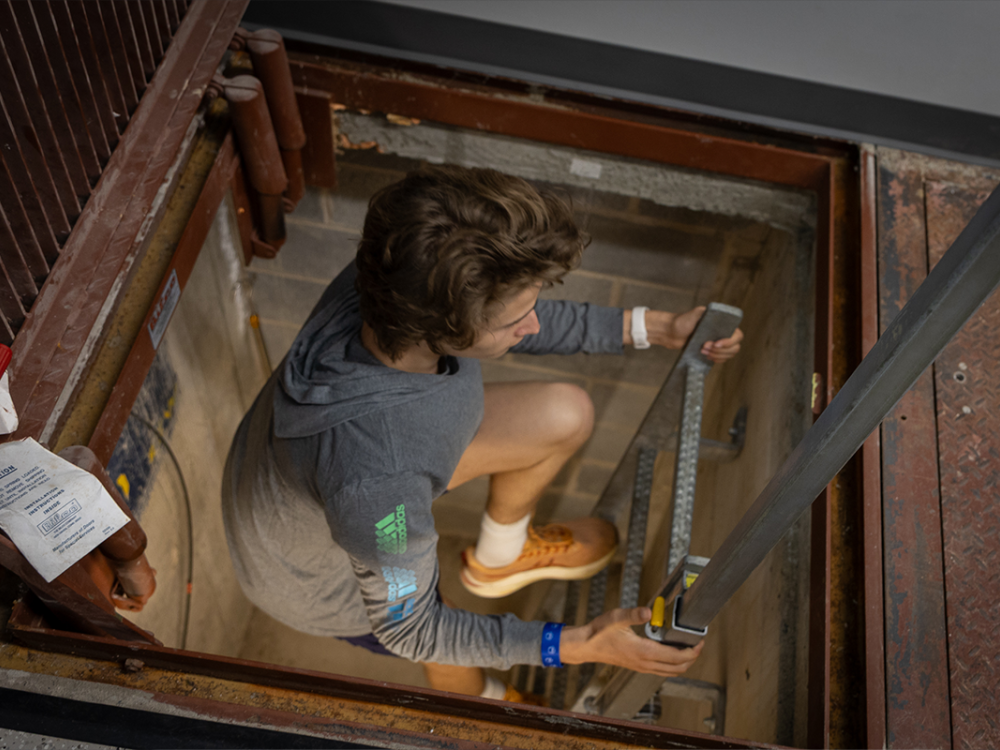 A high school student climbing a ladder.