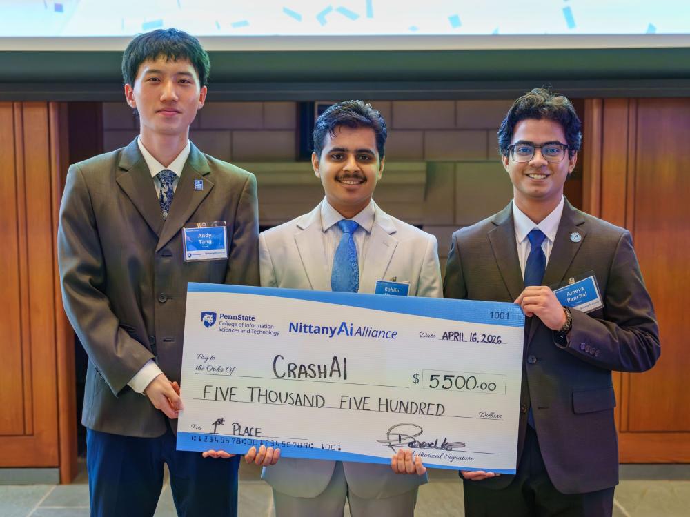 three college students in suits hold giant check