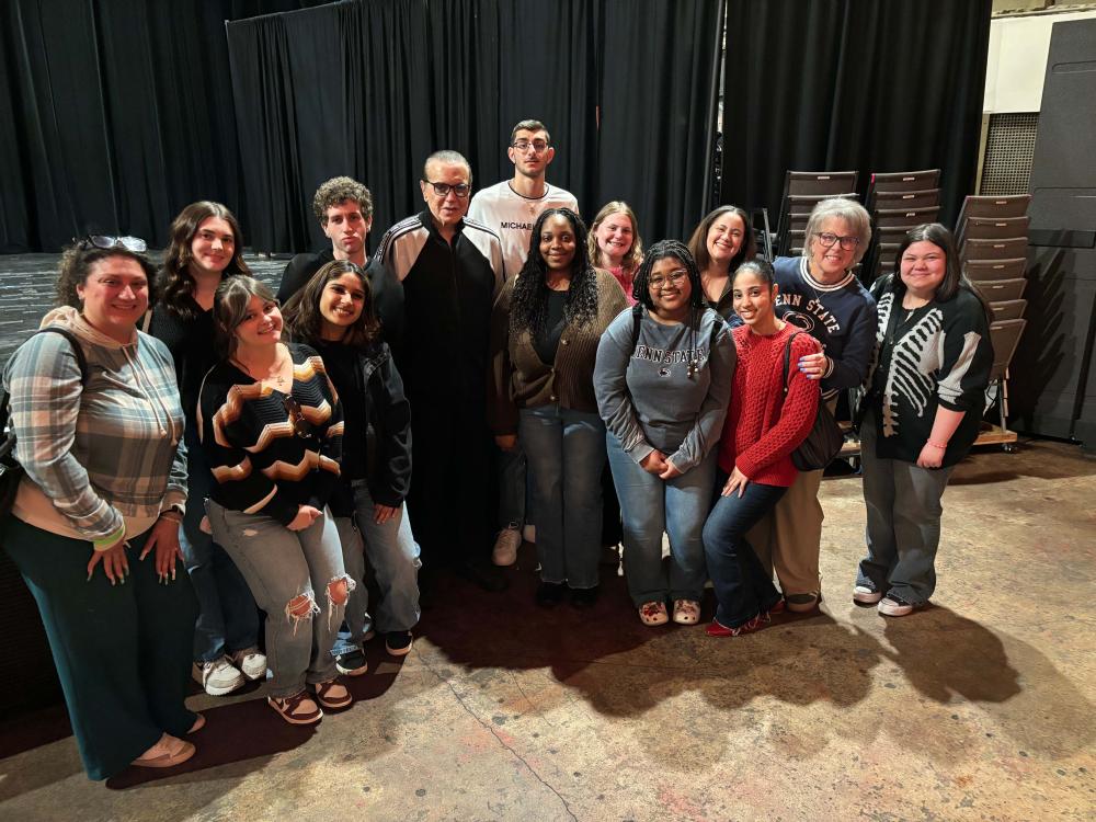 students posing for a photo in front of a stage