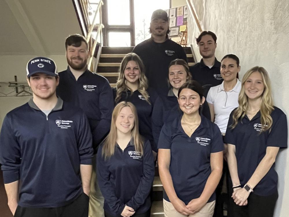 Group of ten students pose for a photo in a stairwell.