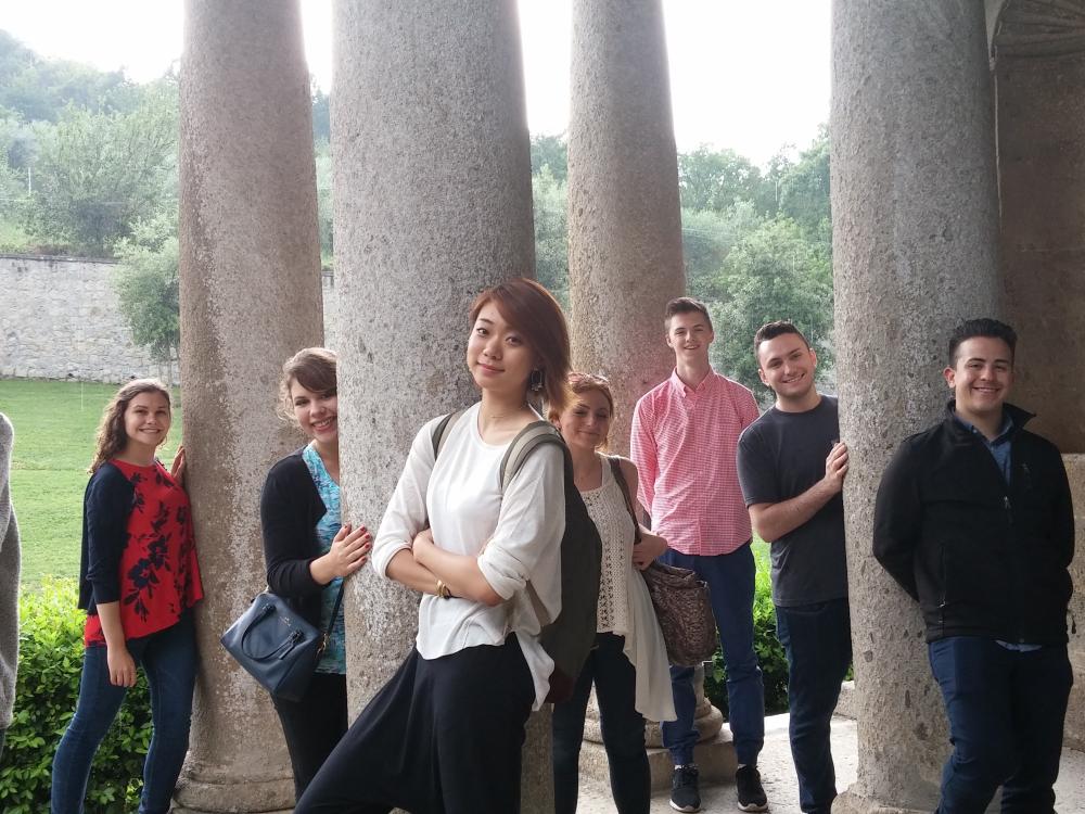 A group of students smile among architecture in Todi.