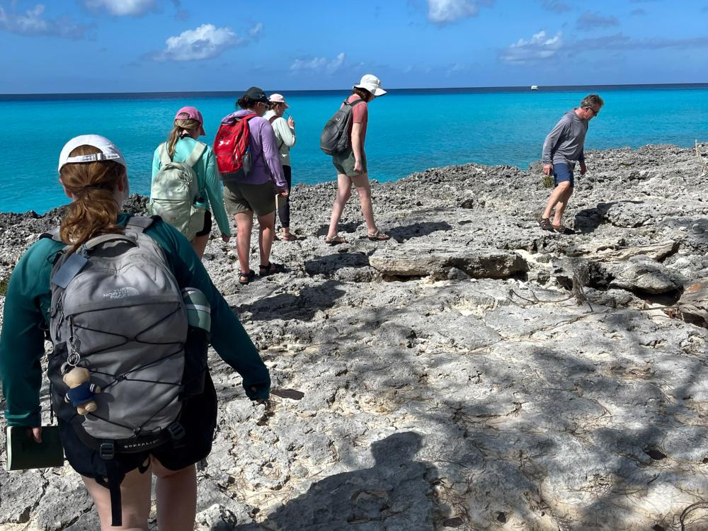 Students walk the coastline of San Salvador island