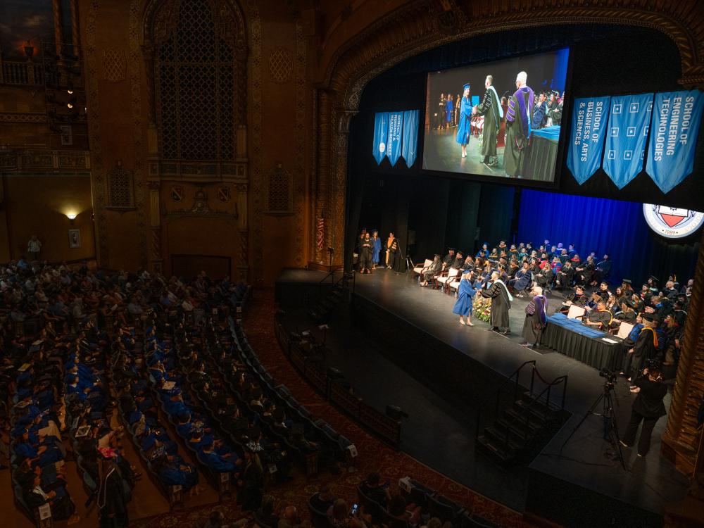 A view of a ceremony on stage from far up in the stands