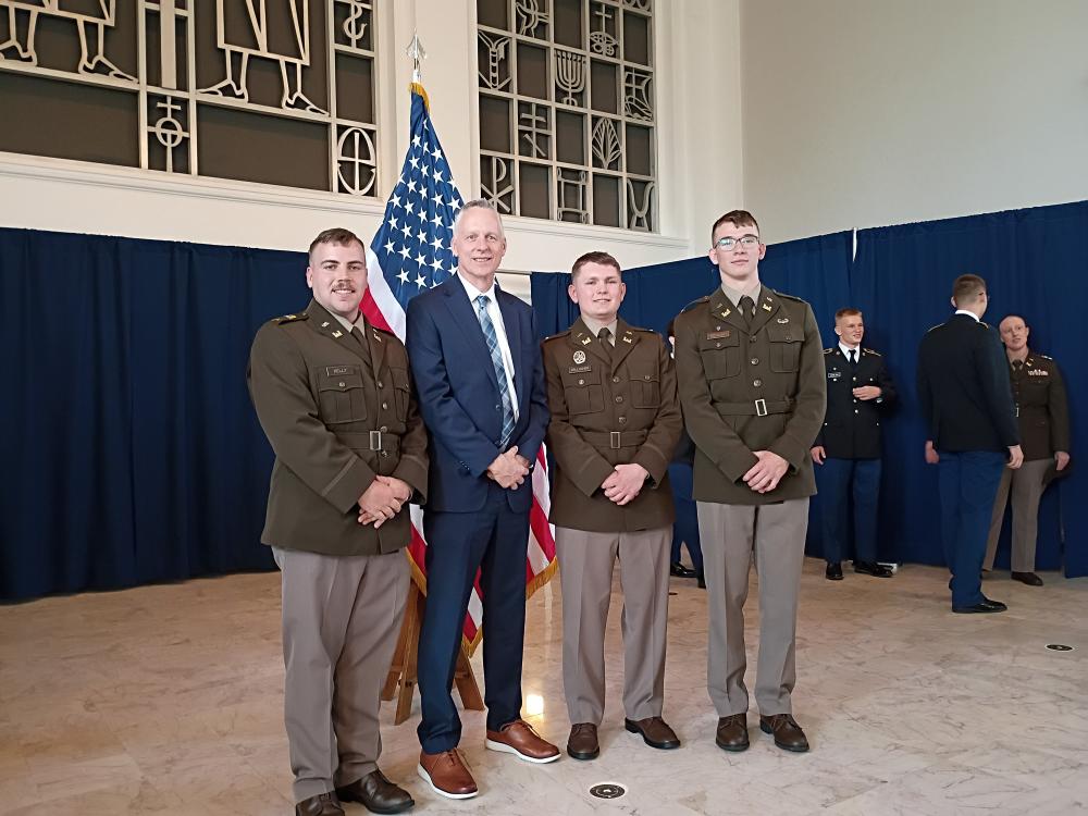 Four men in uniforms pose for a photo.