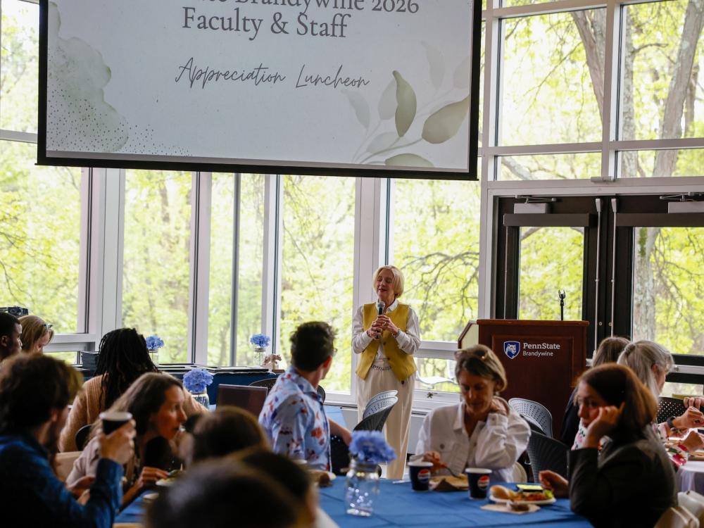 marilyn wells speaking into a microphone in front of a crowd