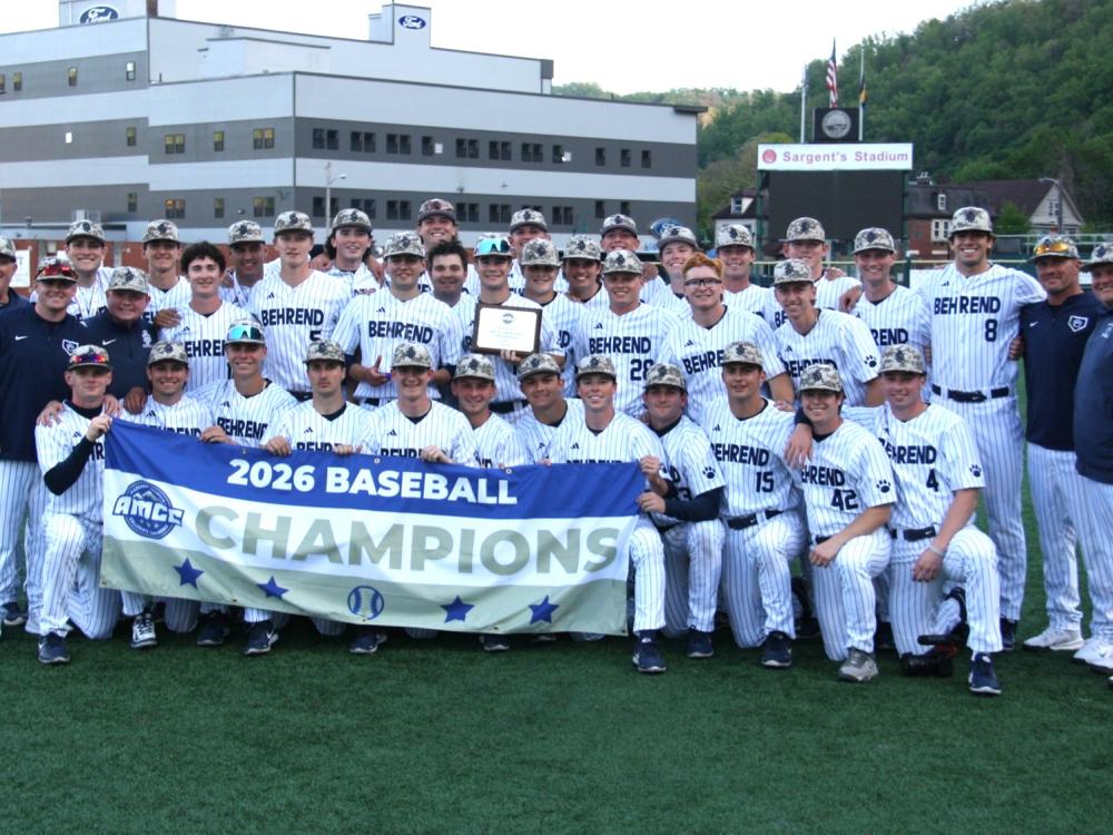 The Penn State Behrend baseball team poses with the AMCC championship banner.