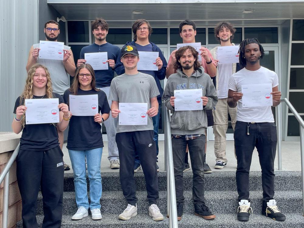 A group of ten students show off their industry certifications