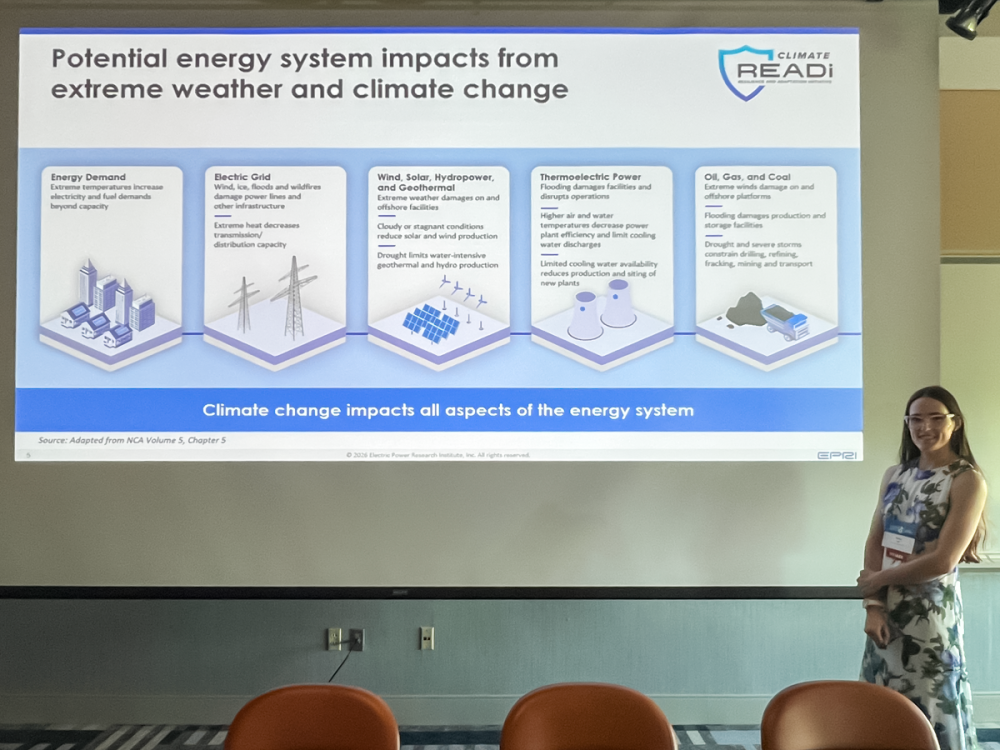 Assistant teaching professor of engineering Courtney Cole stands beside a presentation slide during the Penn State Climate Solutions Symposium at The Penn Stater Hotel and Conference Center on May 19. The slide outlines potential energy system impacts from extreme weather and climate change as part of a Climate READi workshop conducted in partnership with the Electric Power Research Institute.