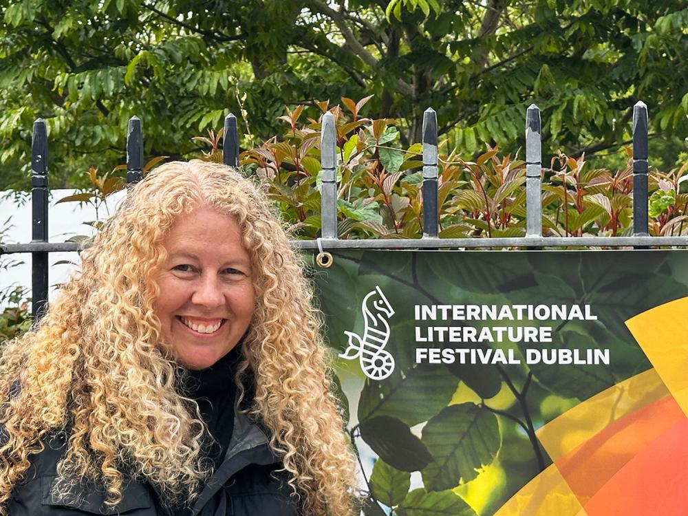 Penn State professor Erin Murphy standing beside banner for International Literature Festival Dublin outdoors.