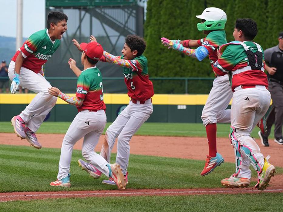 A baseball player jumps in the air to celebrate