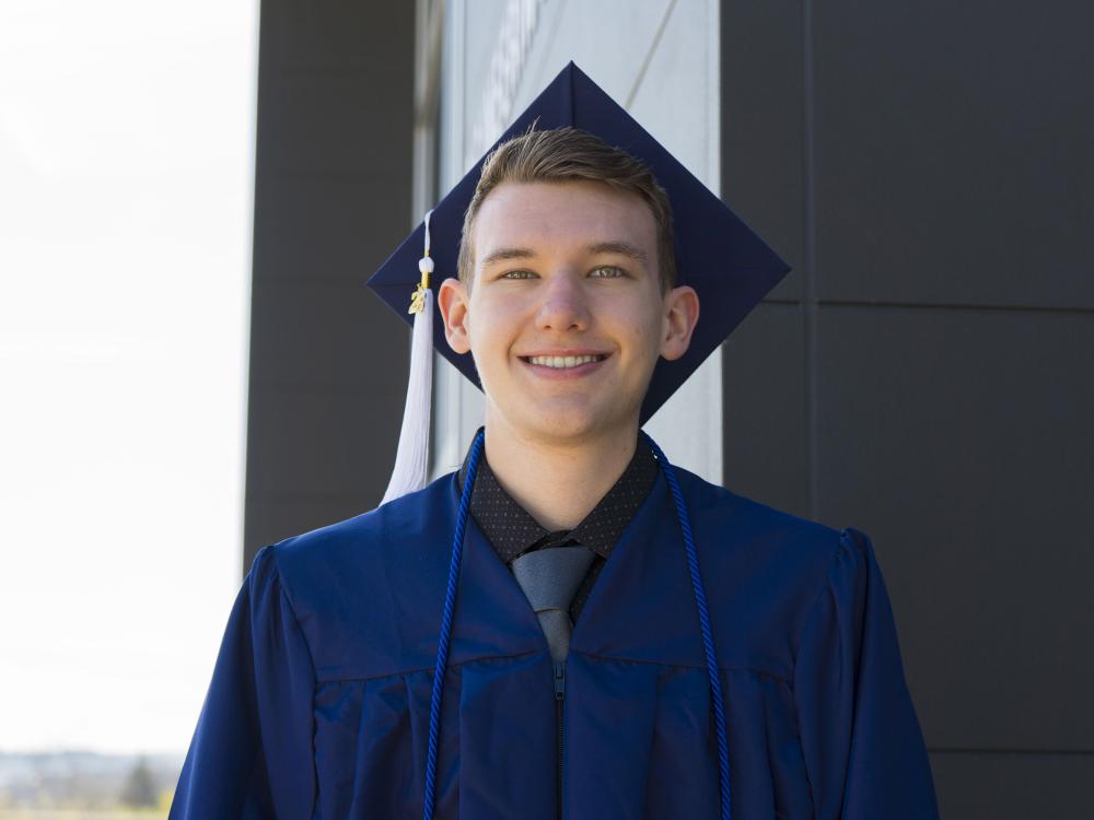 Male student wearing blue commencement regalia