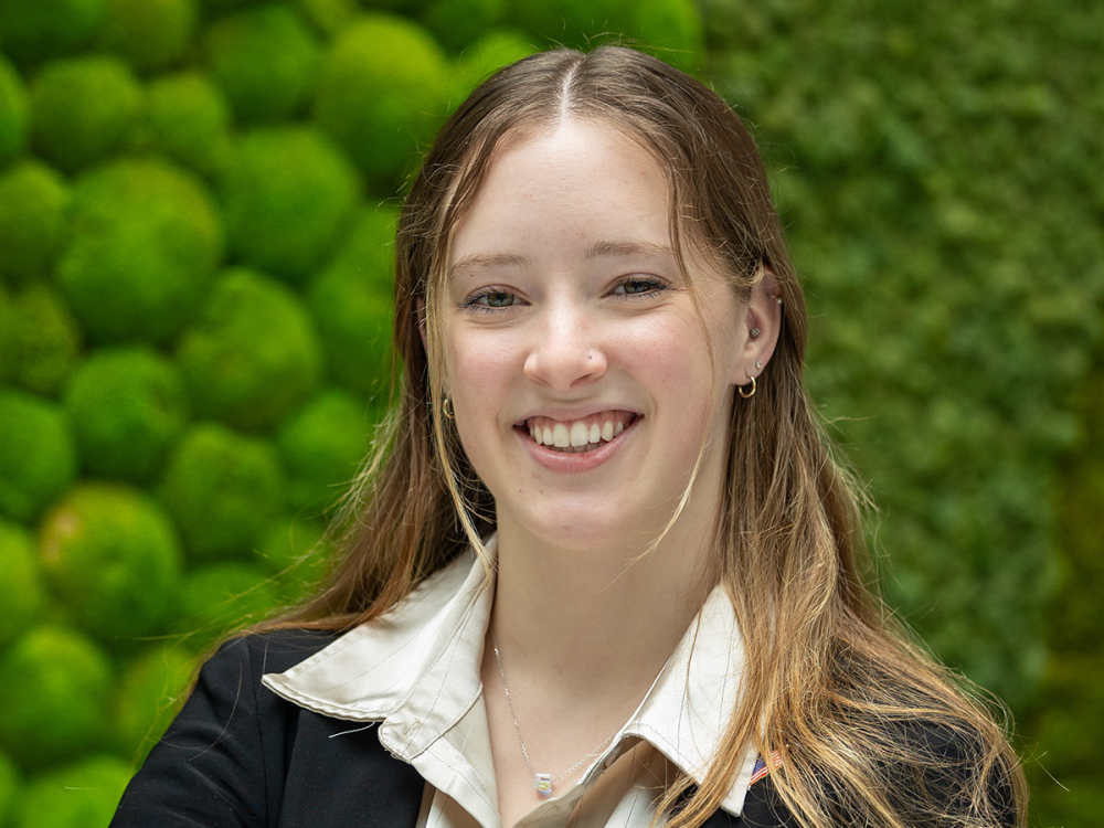 Portrait of Payton Smith posing in front of greenery