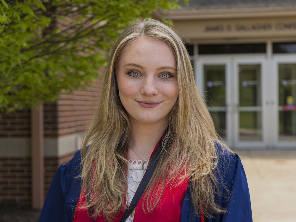 Female student wearing blue commencement regalia