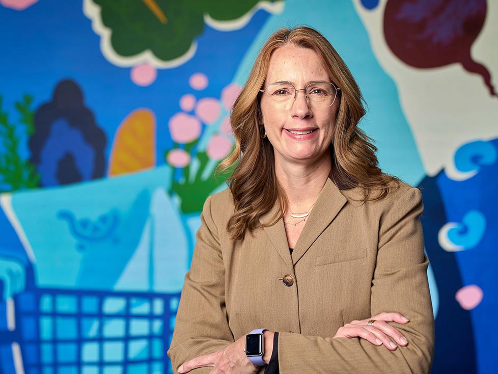 Person standing in front of colorful mural