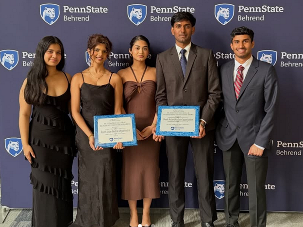 Five Penn State Behrend students pose with a leadership award for their club.