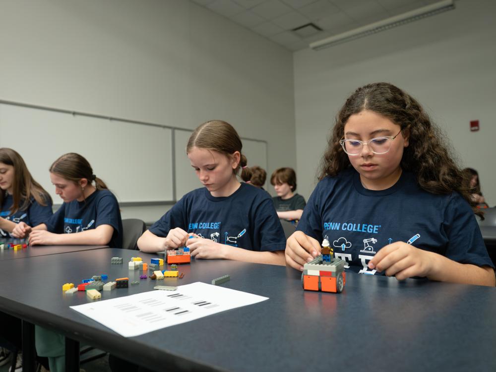 Four students work on robots at a table