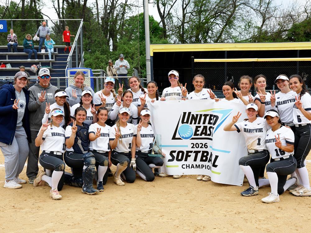 softball team posing with championship banner