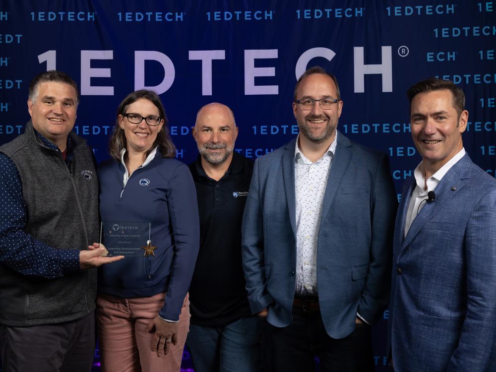 Five people are pictured with an award.