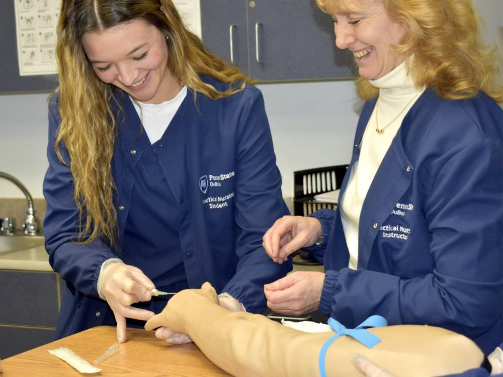 Practical Nursing student Mikayla Grienseisen works through an educational exercise, under the watchful eye of instructor Lisa Dush, RN, MSN, in the Practical Nursing lab at Penn State DuBois.