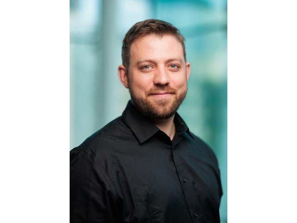 man wearing a dark shirt with a blurry background