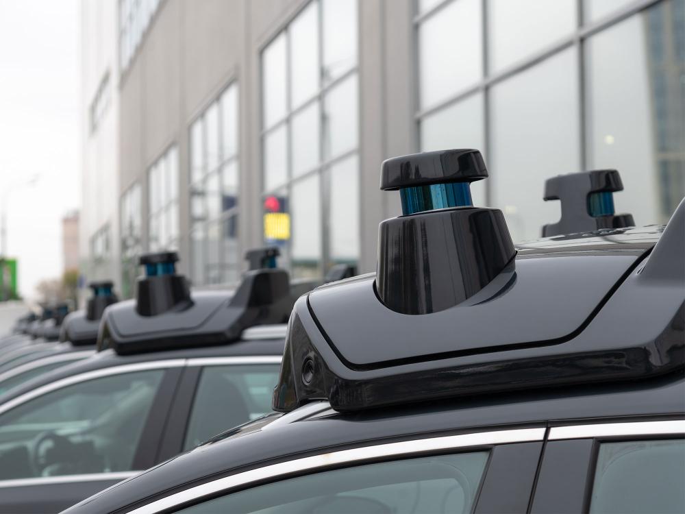 Close-up view of sensors and radar on roof of black autonomous driving vehicle (self-driving car or driverless car).