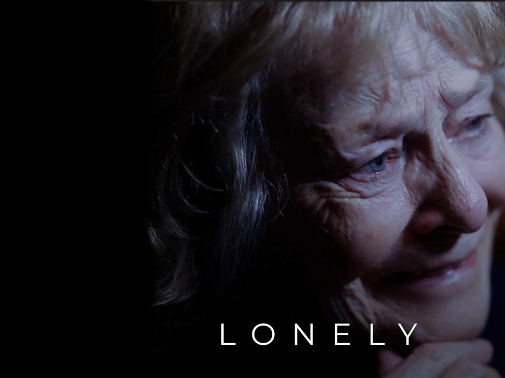 An older woman's face, with the word LONELY at the bottom