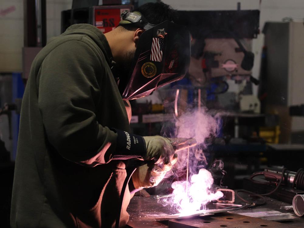 A welding student works on a project
