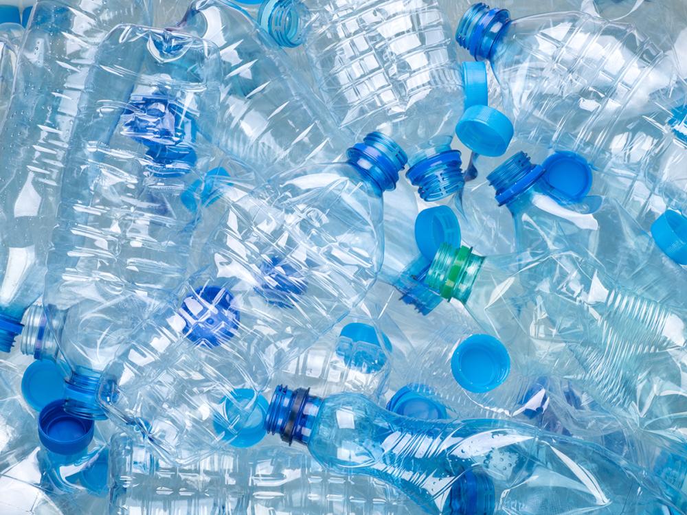 a pile of clear blue, disposable plastic bottles