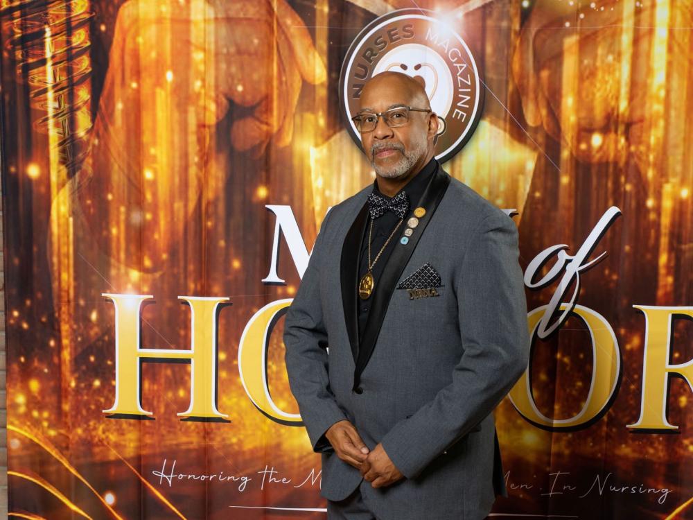 Sheldon D. Fields standing on red carpet in front of banner for The Nurses Magazine's Men of Honor program.