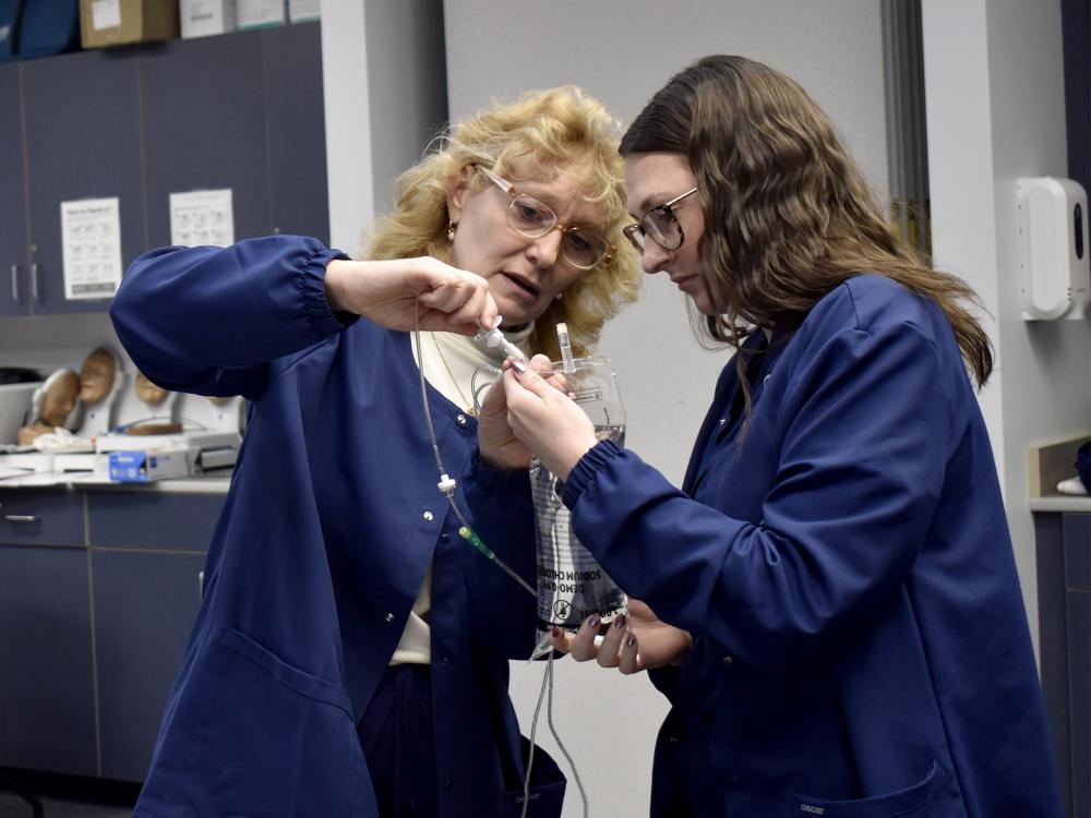 Practical Nursing student Allison Lambert follows guidance of instructor Lisa Dush, RN, MSN, in the Practical Nursing lab at Penn State DuBois.