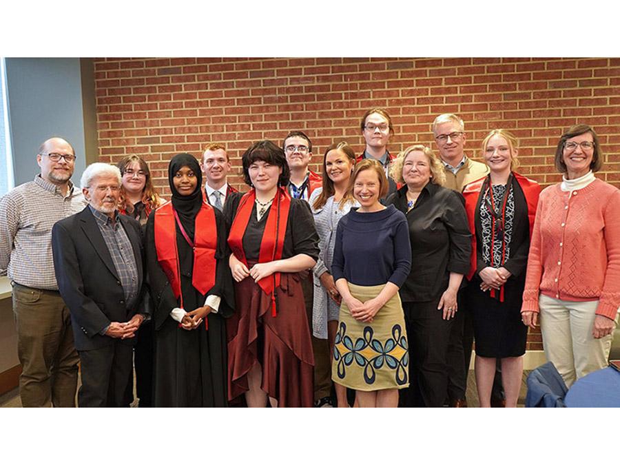 newly inducted honor society students pose with faculty for a group photo