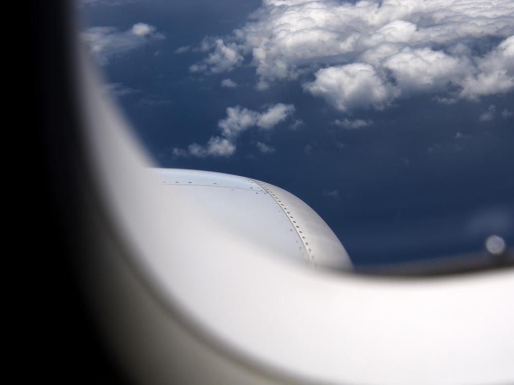 A photo looking outside an airplane in mid-flight, the wing partially in view