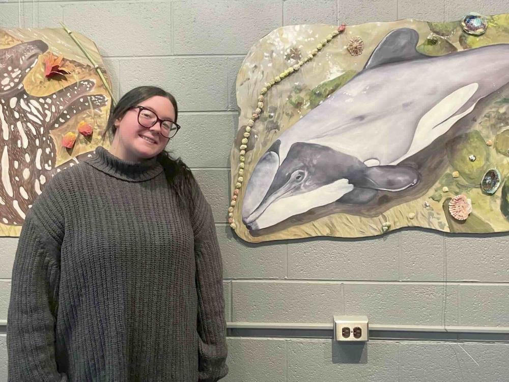 Person standing in front of paintings