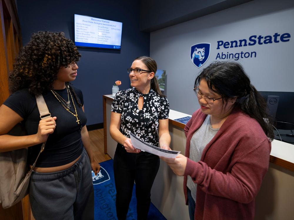 three woman talking and looking at a form