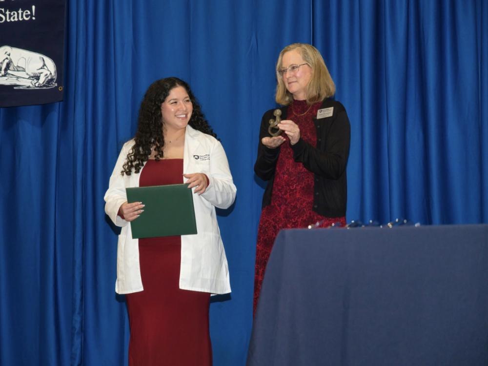 Penn State receives an award presented by her professor. 