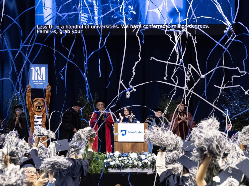 Blue and white streamers fall from the ceiling while a mascot holds a sign that says "1M"