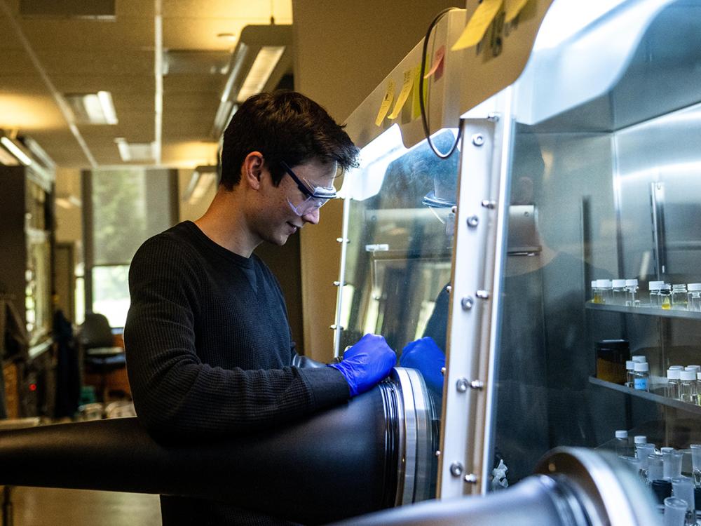 Graduate student Alexander Arnette working in chemistry lab hood.